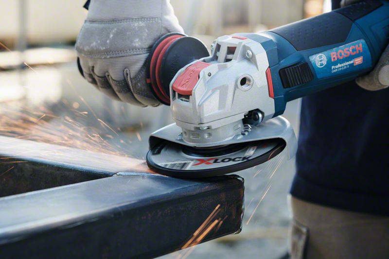 Eine Person verwendet eine Bosch-Winkelschleifmaschine, um Metall zu schleifen. Funken fliegen vom bearbeiteten Werkstück.