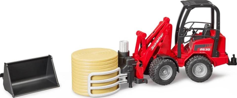 Ein roter Spielzeugtraktor mit Frontlader-Arm, Schaufelaufsatz und runden Heuballenringen. Geeignet für landwirtschaftliches Spiel.