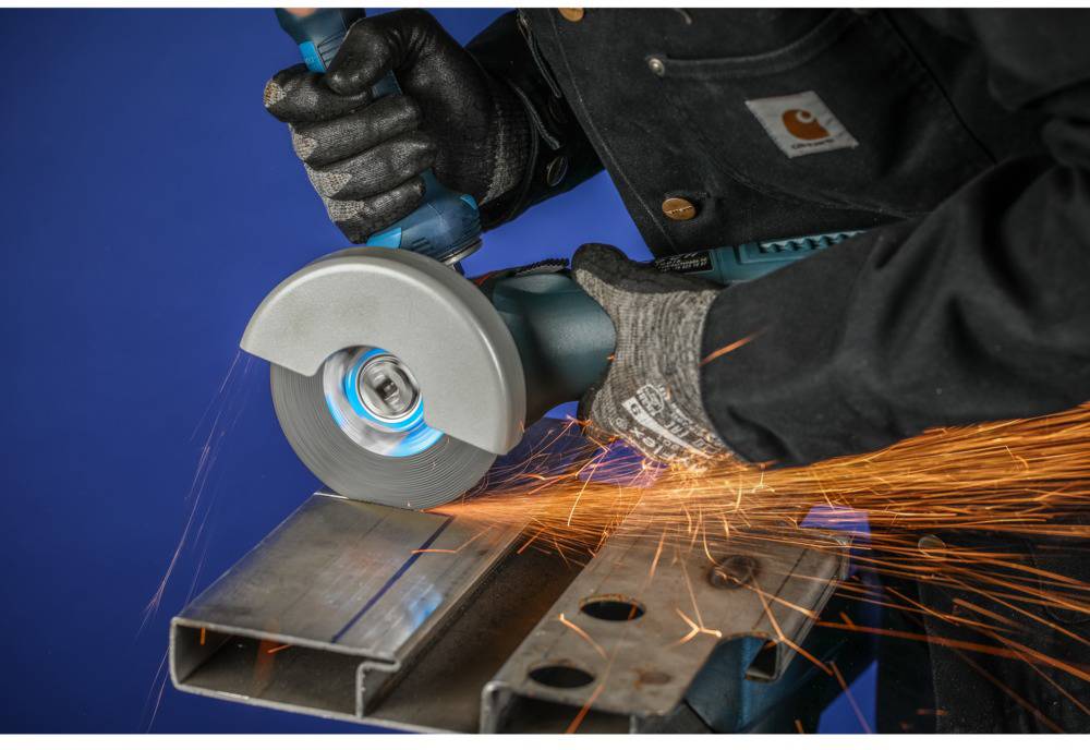 Eine Person schleift Metall mit einer elektrischen Schleifmaschine. Funken fliegen von der Stelle, an der das Werkzeug das Metall berührt.