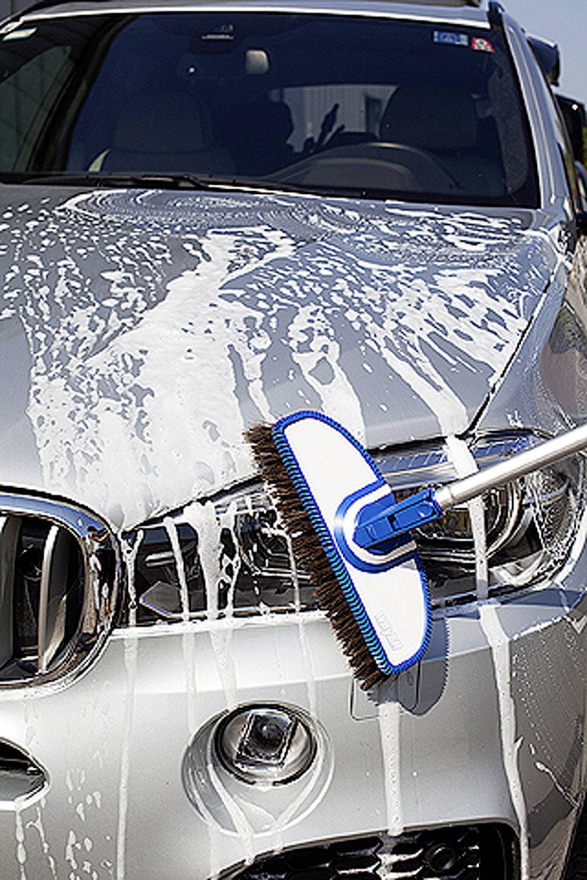 Auto wird mit Schaum und Bürste gewaschen, Vorderansicht.