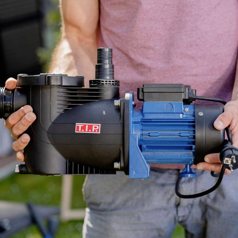 Eine Person hält eine blau-schwarze Wasserpumpe mit der Aufschrift 