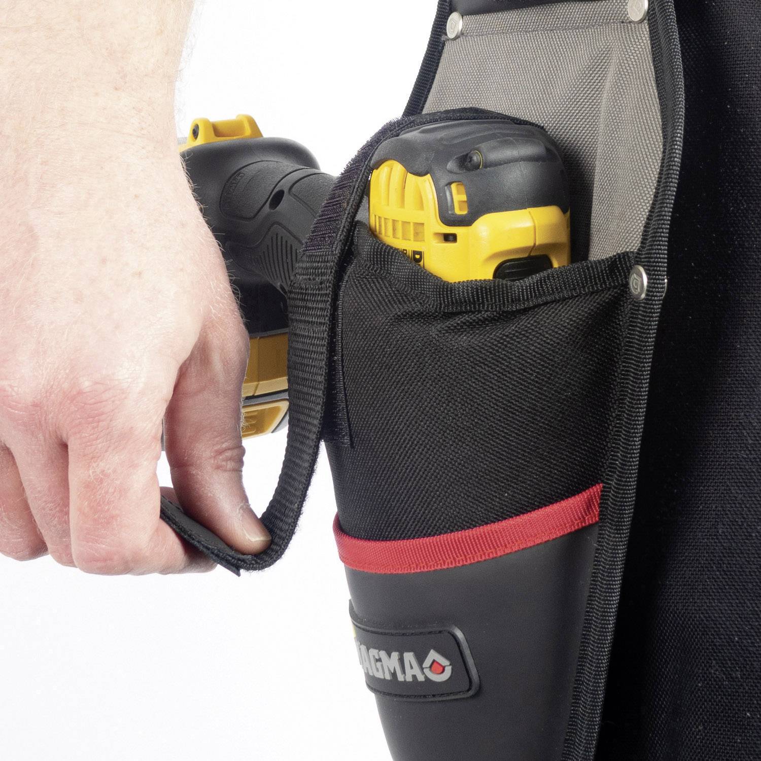 Eine Person hält ein Elektrowerkzeug, das in einer schwarzen und roten Tasche mit der Aufschrift 'Magma' steckt.
