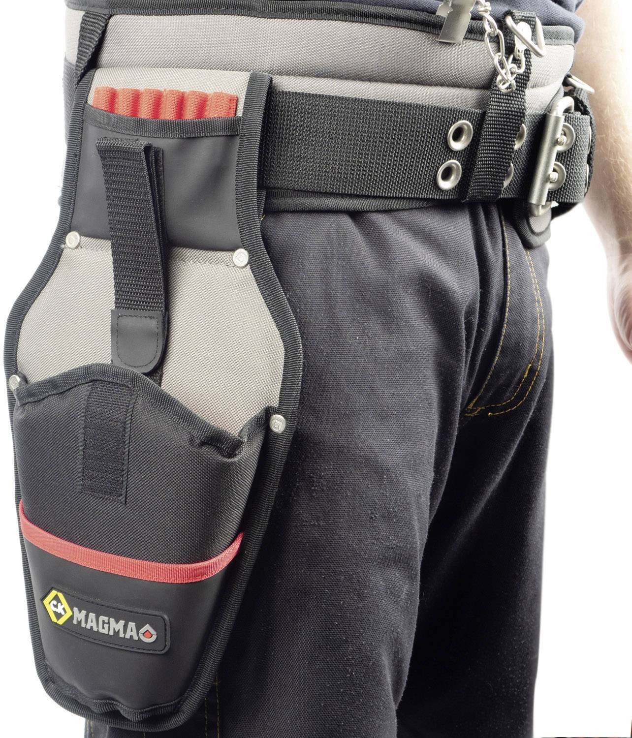 Person trägt einen schwarzen Werkzeuggürtel mit einer großen Tasche und roten Griffen. Die Tasche ist mit dem Logo 'MAGMA' versehen.