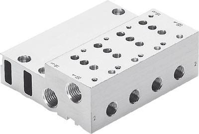 Ein silberner Metallblock mit mehreren Bohrungen und Gewinden, vermutlich ein Teil eines technischen oder mechanischen Systems.