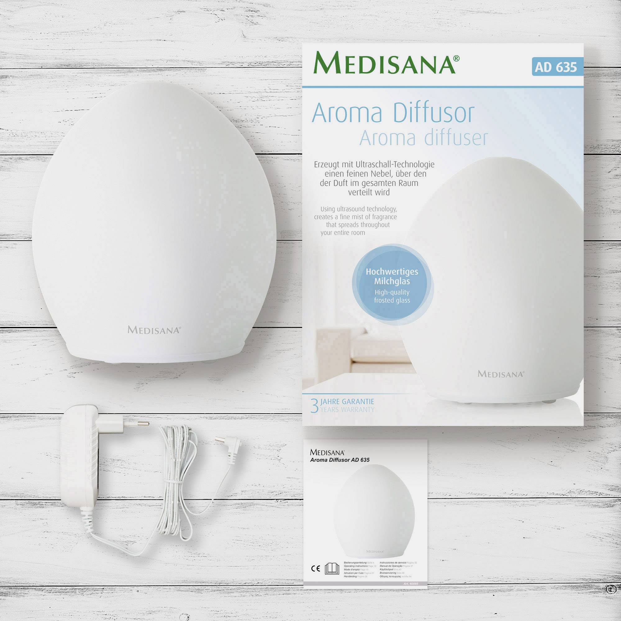 Der Medisana Aroma-Diffusor AD 635 vor einer Holzoberfläche, neben ihm Verpackung und Kabel. Fördert Aromatherapie im Raum.