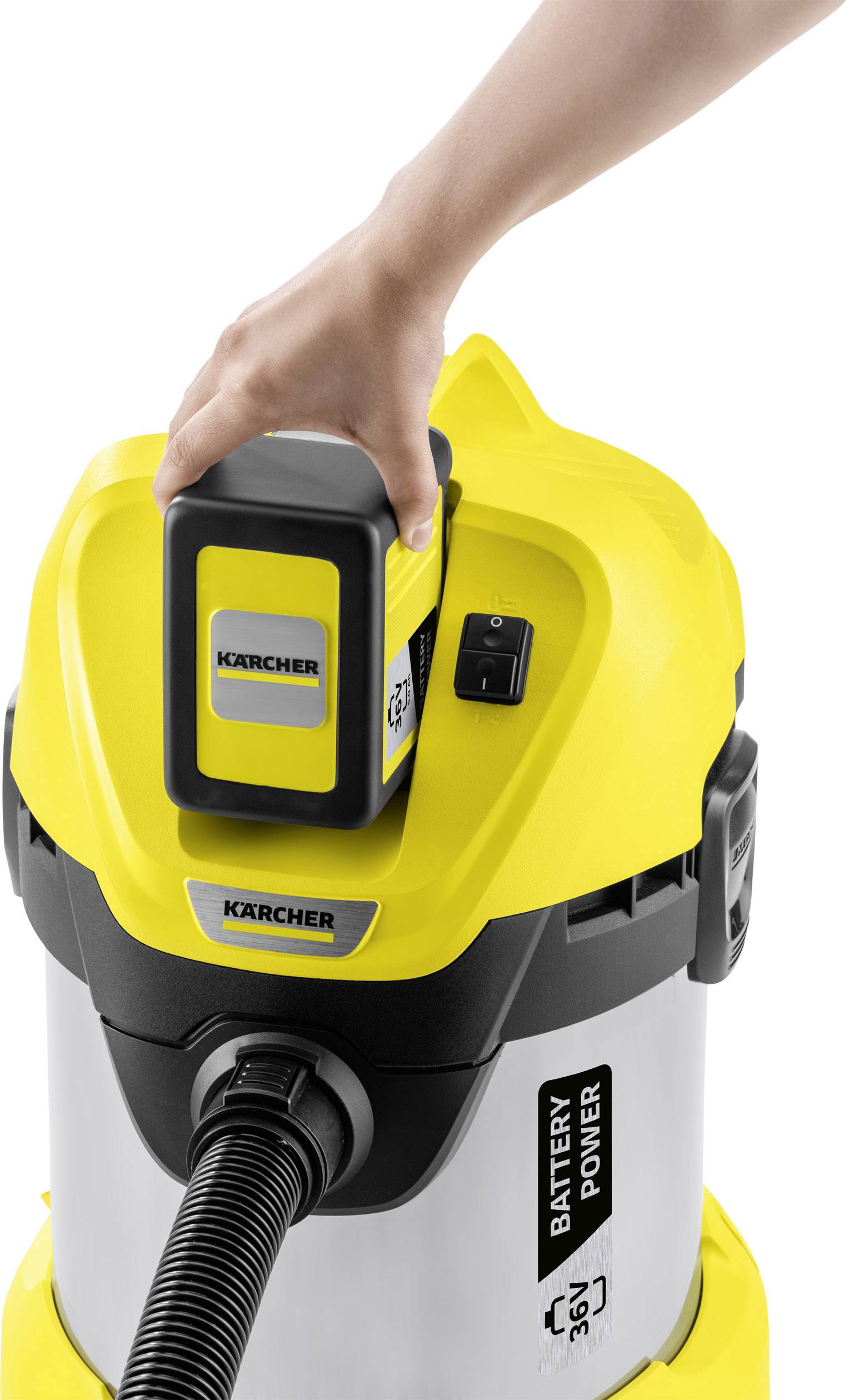 Eine Hand setzt eine Batterie in einen gelben Industriesauger ein.