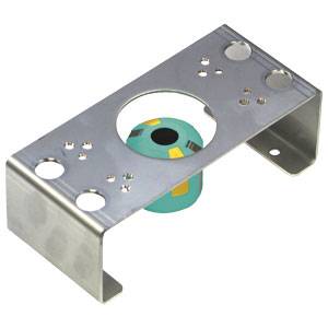 Metallhalterung mit Bohrungen und einem grünen, zylindrischen Objekt in der Mitte, vermutlich ein Befestigungselement.