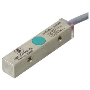 Rechteckiger Magnetsensor mit metallischem Gehäuse, Kabelverbindung und grüner Markierung oben. Markierungen und technische Details erkennbar.
