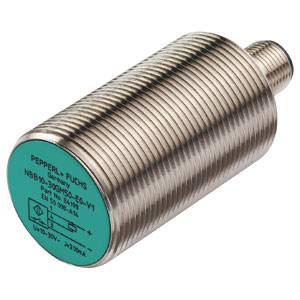 Zylindrischer induktiver Sensor von Pepperl+Fuchs, Modell NBB50-U1-E2-V1. Metallgehäuse mit grünem Etikett und technischen Spezifikationen.