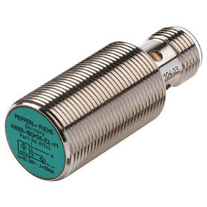 Zylindrischer Sensor mit metallischem Gehäuse, Herstelleraufdruck und technischen Spezifikationen auf grünem Etikett sichtbar.