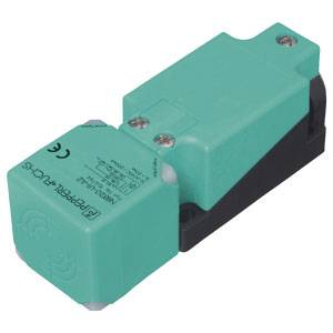 Elektronischer Sensor in einem grünen Kunststoffgehäuse. Das Gerät hat zwei Schrauben zur Befestigung und ist für industrielle Anwendungen geeignet.