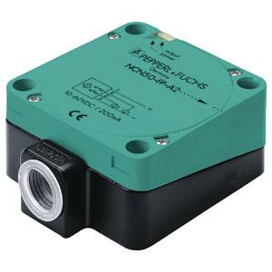 Ein quadratischer Sensor von Pepperl+Fuchs, Modellnummer NQN50-WP-A2, in den Farben Grün und Schwarz, mit einer Anschlussbuchse.