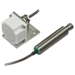 Ein zylindrischer Sensor mit Kabel neben einer weißen, rechteckigen Halterung. Der Sensor wird vermutlich für technische Anwendungen genutzt.