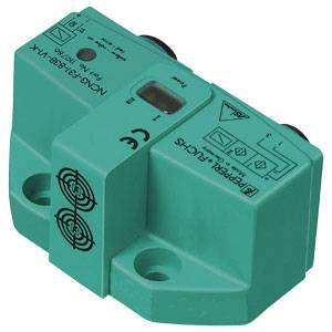 Ein rechteckiger grüner elektrischer Sensor mit CE-Kennzeichen und verschiedene technische Symbole und Beschriftungen darauf.