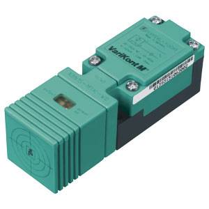 Ein rechteckiger, grüner Sensor mit der Aufschrift 'VariKont M'. Der Sensor hat eine geriffelte Oberfläche und ist für industrielle Anwendungen geeignet.