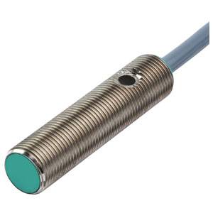 Ein zylindrischer, metallischer Näherungssensor mit geriffeltem Gehäuse, grüner Spitze und Kabel, zur Erfassung von Objekten.