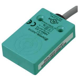 Ein rechteckiger türkisfarbener Sensor mit dem Aufdruck 'Pepperl+Fuchs'. Er hat Kabelanschluss und verschiedene Zertifizierungslogos.