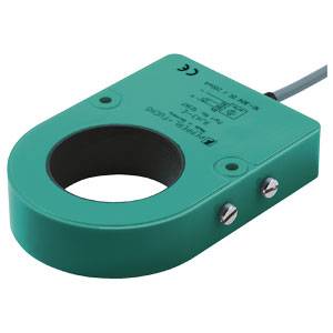 Ein grüner Sensor mit Rundöffnung und zwei Metallschrauben, zur Erfassung elektrischer Ströme, mit angeschlossenem Kabel.
