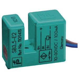 Ein rechteckiger, türkisfarbener Sensor mit Beschriftung 'SB3.5-E2', '10-30VDC/100mA'. Aufdruck zeigt Plus- und Minussymbole.