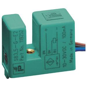Ein grüner Sensor mit Aufschrift '10-30VDC / 100mA', 'Part No. 19952', hergestellt in Deutschland, zeigt Schaltsymbole an.