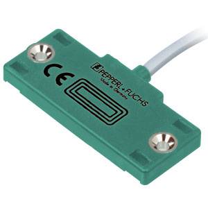 Grüner Sensor von Pepperl+Fuchs mit CE-Kennzeichnung. Rechteckige Form mit vier Befestigungsöffnungen an den Ecken. Kabelanschluss oben.