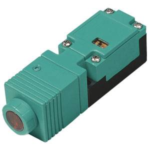 Ein grüner, rechteckiger Induktivsensor mit rotem Sensorbereich und Metallschrauben. Hauptanwendung in automatisierten Systemen.