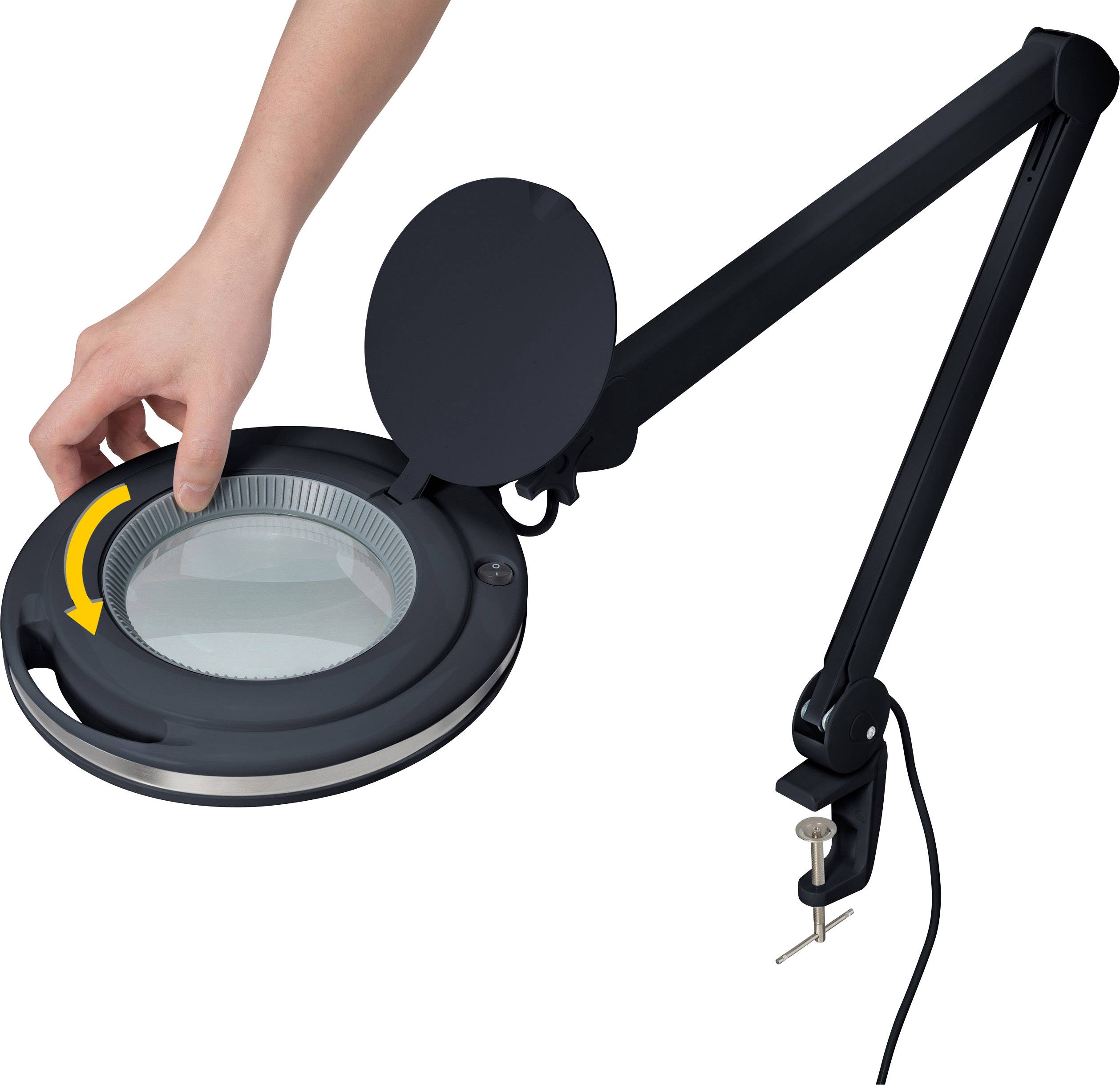 Hand dreht Abdeckung einer schwarzen, flexiblen Lupenlampe mit rundem Glas. Die Lampe hat einen Schwenkarm und eine Tischklemme.