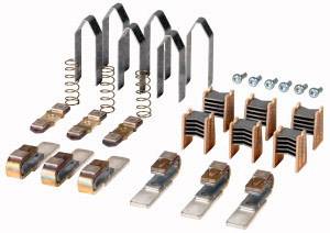 Ein Set von Bremszubehörteilen, darunter Clips, Federn und Schrauben, liegen geordnet auf einer weißen Fläche.