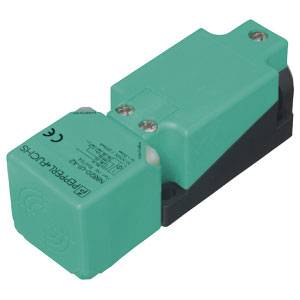 Ein grüner, rechteckiger Sensor oder Schalter mit schwarzem Boden, darauf technische Spezifikationen gedruckt. Geeignet für industrielle Anwendungen.