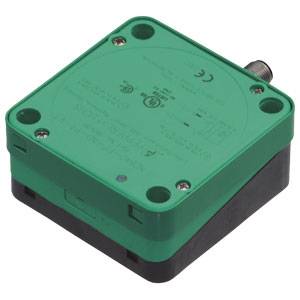 Grüne elektronische Box mit schwarzen Kanten und vier Schraubpunkten auf jedem Eck. Eine silberne Anschlussstelle oben rechts.