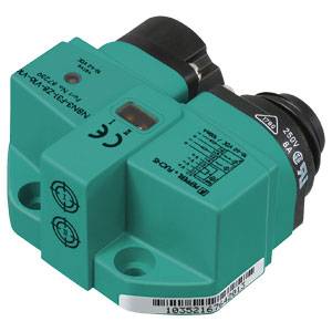 Ein grüner elektrischer Sensor mit Herstelleraufdruck und CE-Kennzeichnung. Er hat zwei schwarze Anschlüsse und ein Barcode-Etikett.