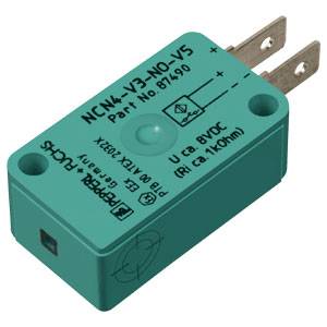 Elektrischer Sensor, rechteckig, türkisfarben, mit Kontakten und Aufschrift 'NCN4-V3-NO-V5' und technischen Details obenauf.