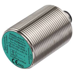 Zylindrischer Metallsensor mit grüner Frontplatte und Aufschrift. Hersteller ist Pepperl+Fuchs. Gerät ist ATEX-zertifiziert für explosionsgefährdete Bereiche.