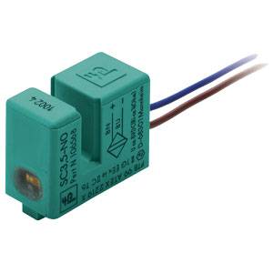 Ein grüner, rechteckiger Sensor mit der Aufschrift 'SC3,5-NO'. Es hat blaue und braune Drähte an der Rückseite.