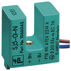 Ein rechteckiger, grüner Sensor mit dem Aufdruck 'SJ5-G-N' und technischen Informationen. Kabel verlaufen seitlich.