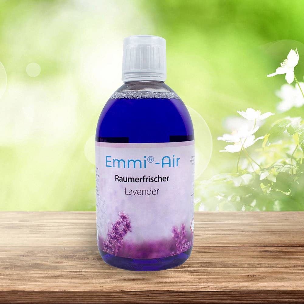 Blaues Raumerfrischer-Spray 'Emmi-Air Lavendel' auf Holztisch vor unscharfem Hintergrund mit Gras und weißen Blüten.