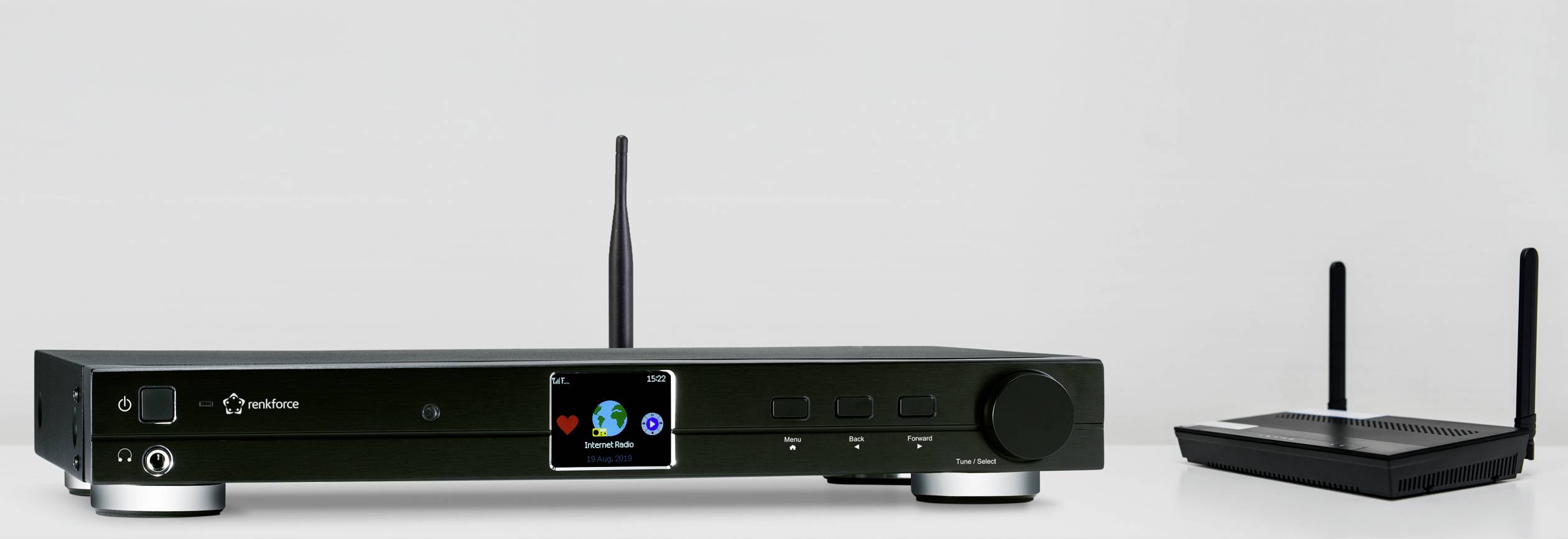 Ein schwarzer Stereo-Receiver mit Antenne links und ein kleiner WLAN-Router mit zwei Antennen rechts auf einem weißen Hintergrund.