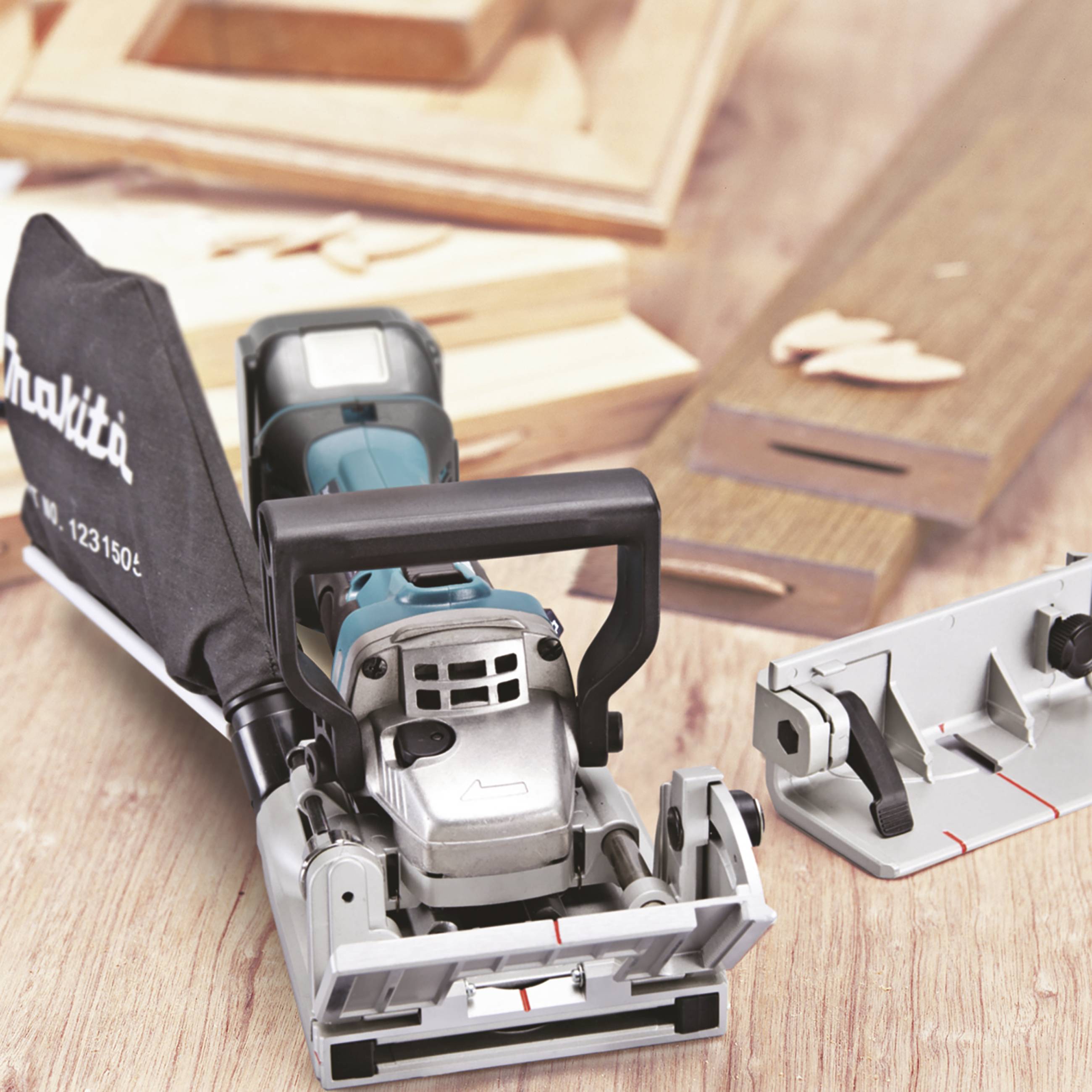 Eine elektrische Holzfräse auf einer Werkbank, umgeben von Holzbrettern und Werkzeugen, zeigt Anwendungen im Tischlerhandwerk.