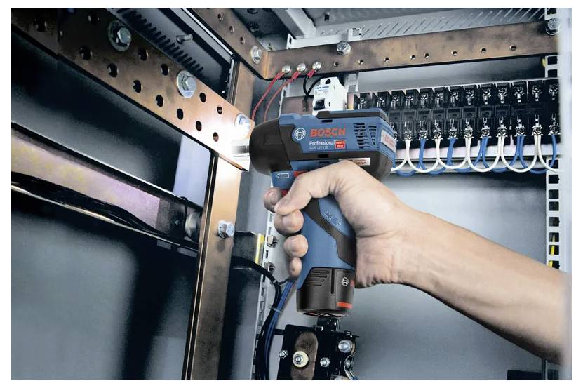 Eine Person verwendet eine Wärmebildkamera von Bosch in einer Elektroverteilungsanlage und analysiert Temperaturunterschiede auf mögliche Störungen.