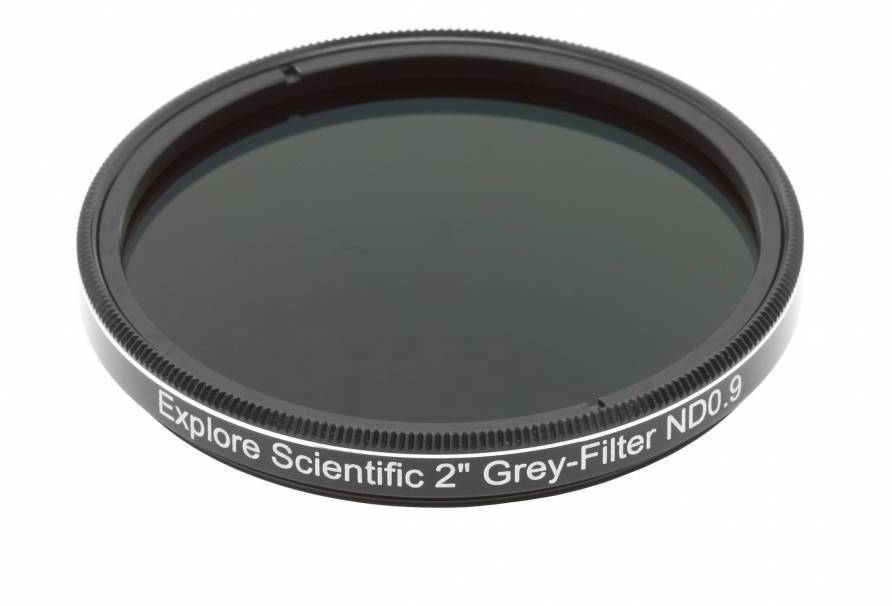 Ein grauer ND-Filter von 'Explore Scientific' mit 2 Zoll Durchmesser und einer ND-Stärke von 0.9 liegt auf einer weißen Oberfläche.