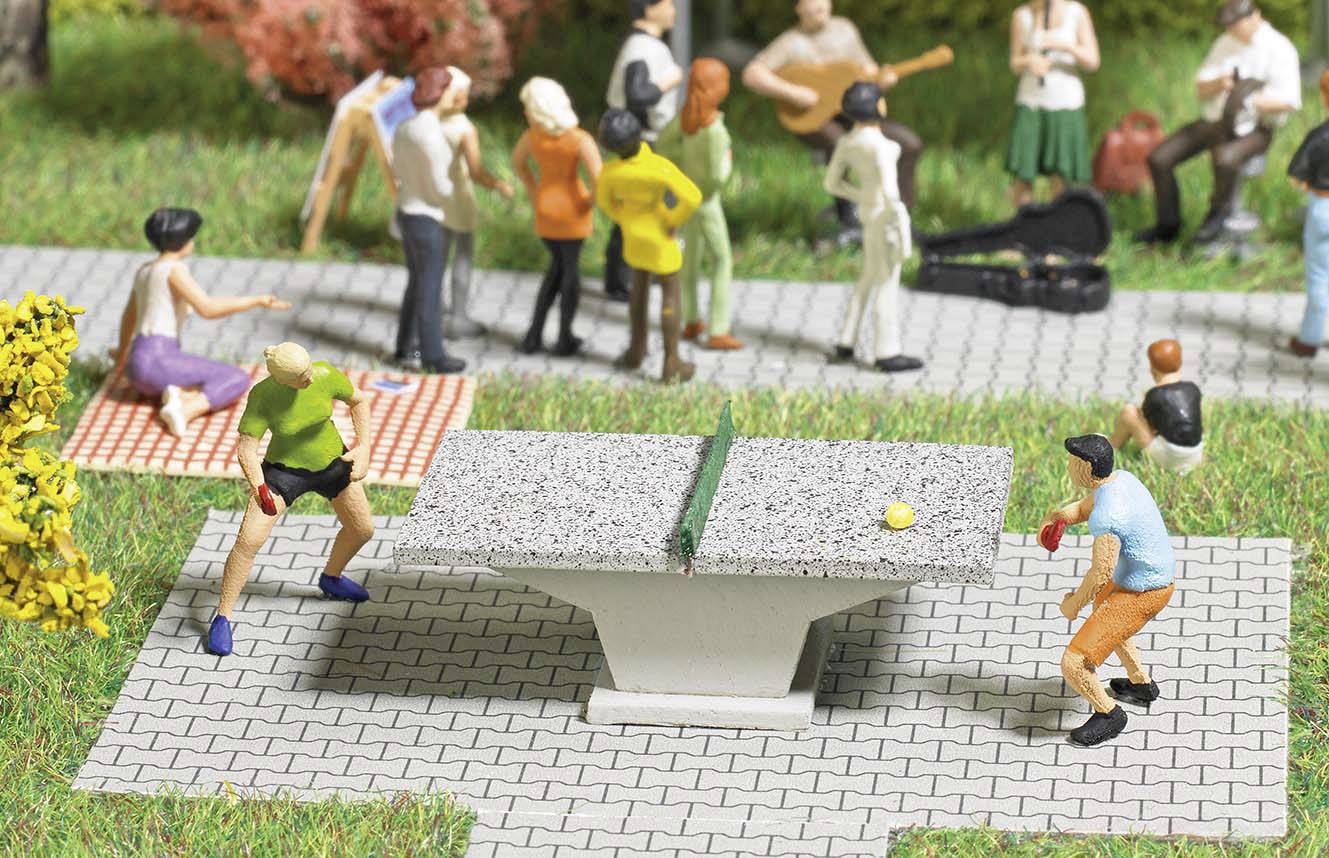 Zwei Figuren spielen Tischtennis auf einem kleinen Tisch im Vordergrund, während im Hintergrund weitere Figuren eine entspannte Parkszene darstellen.
