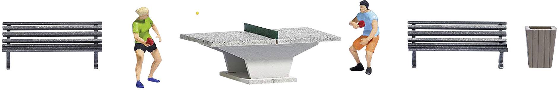 Zwei Personen spielen Tischtennis auf einem Steinplattentisch im Park, umgeben von Parkbänken und einem Abfalleimer.