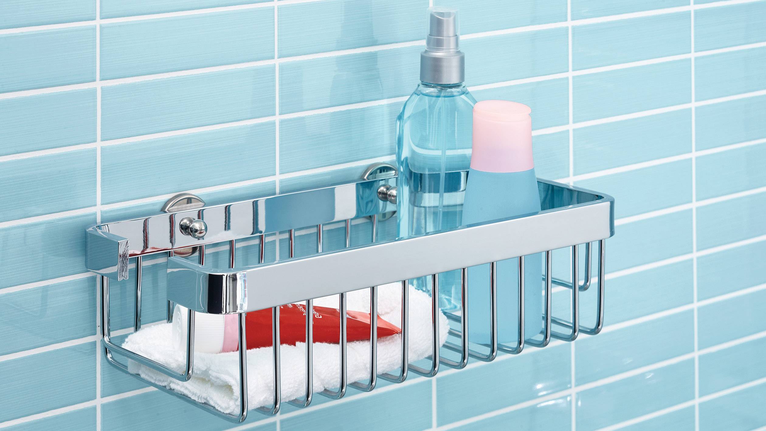 Duschregal mit Shampoo und Körperpflegeflaschen vor blauen Kacheln; oben Gleitschutzbeschichtung.