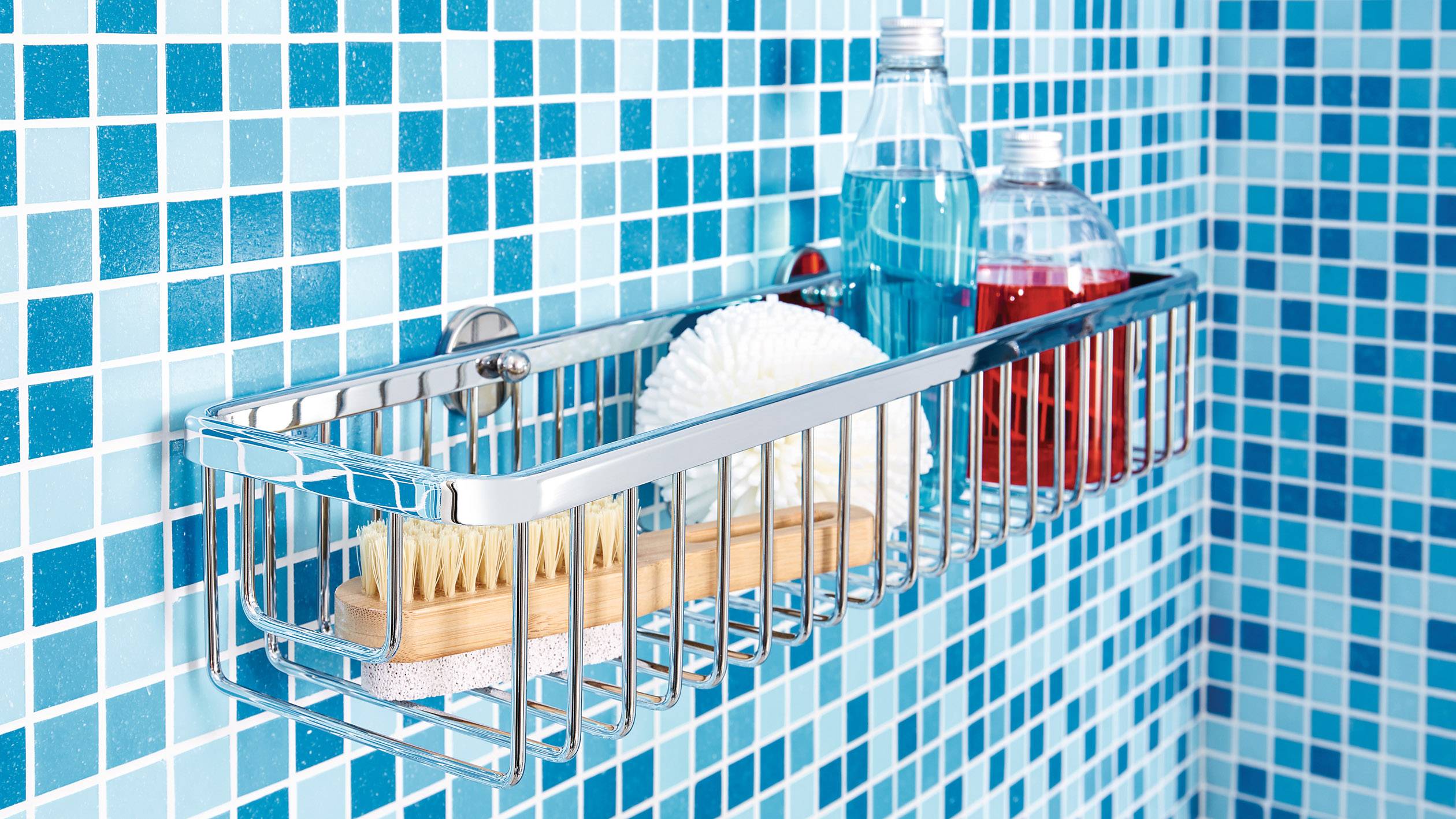 Duschablage aus Metall, befestigt an einer blau gefliesten Wand, enthält Bürste, Duschgel und Schwamm.