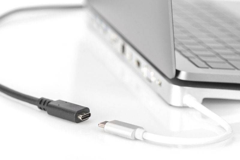 Ein Laptop mit einem eingesteckten Ladekabel, daneben ein weiteres USB-C-Kabel, bereit zum Verbinden mit dem Computer.