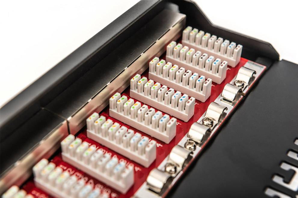 Nahaufnahme eines Patchfelds mit mehreren Reihen bunter Ethernet-Kabelanschlüsse. Es wird in einem Netzwerkverteilungssystem verwendet.