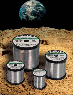 Spulen aus Edelstahl verschiedener Größen auf sandigem Boden mit der Erde im Hintergrund.