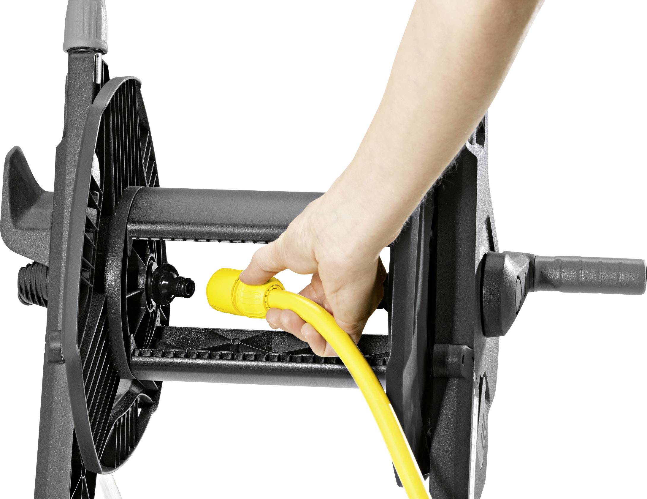 Eine Person zieht ein gelbes Kabel von einer schwarzen Kabeltrommel.