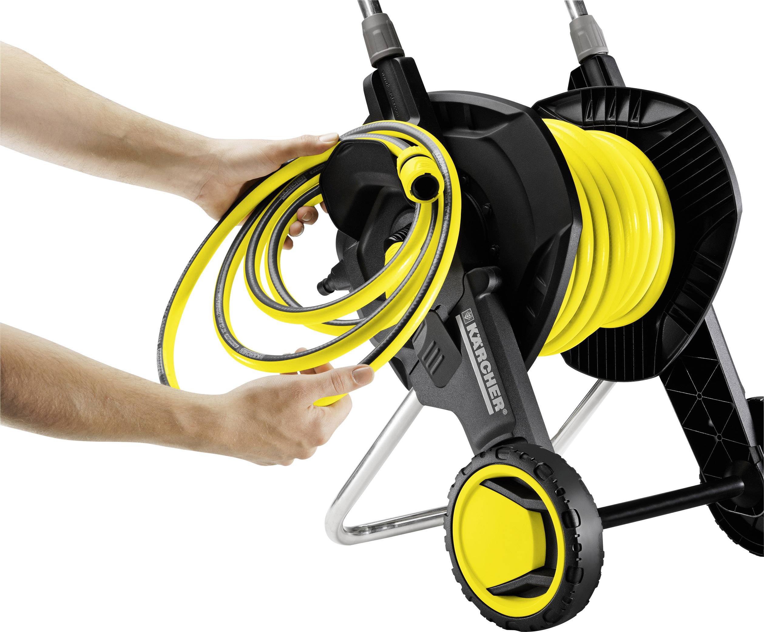 Eine Person rollt einen gelben Gartenschlauch auf einen schwarzen Schlauchwagen mit gelben Rädern auf, Markenaufdruck sichtbar.