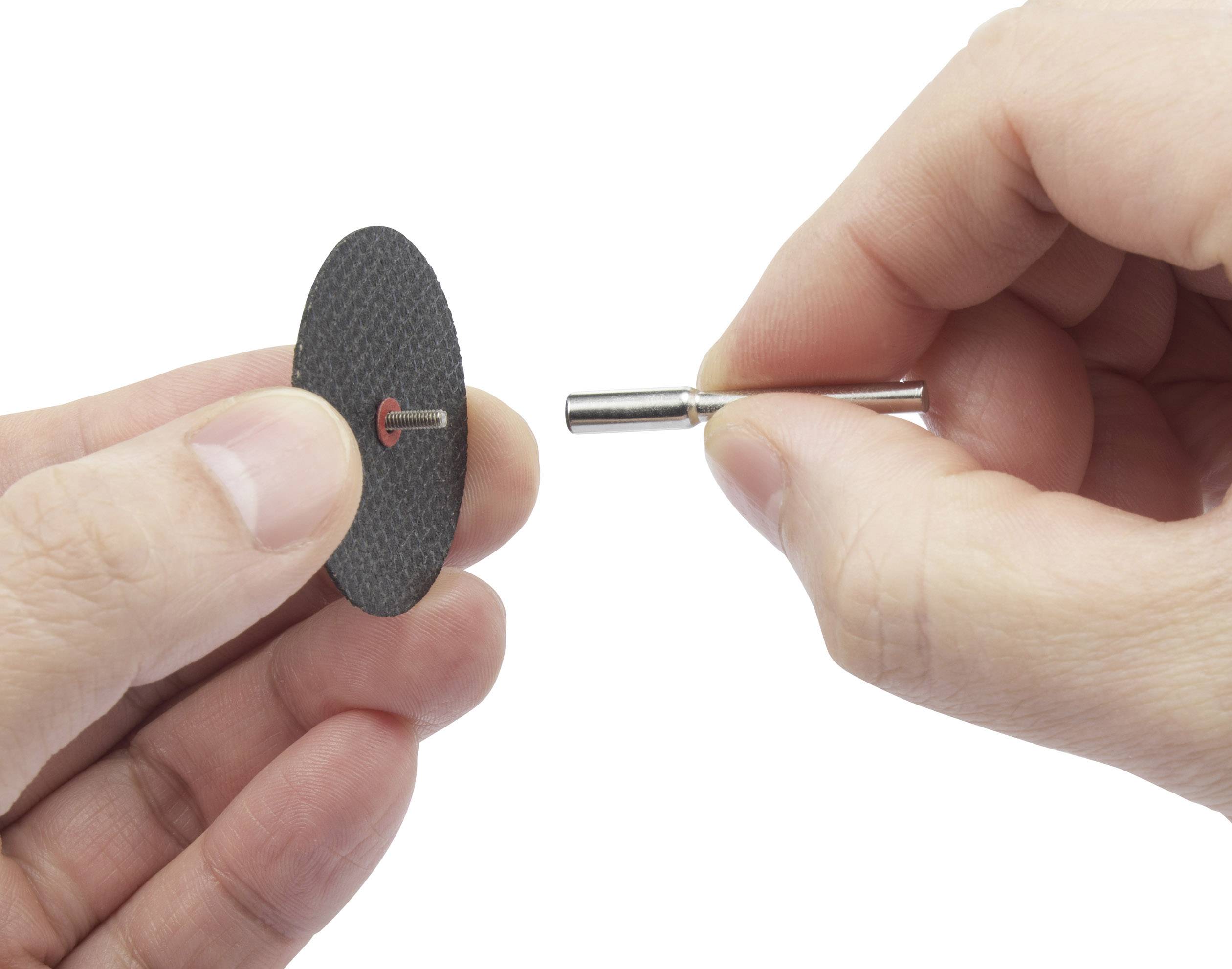 Zwei Hände halten eine kleine Trennscheibe und einen Dremel-Bohrer. Die Trennscheibe ist bereit, am Bohrer befestigt zu werden.